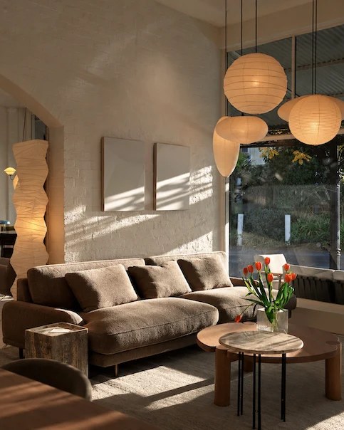 Inside In Good Company: arched white walls, paper globe pendants and a deep bouclé sofa